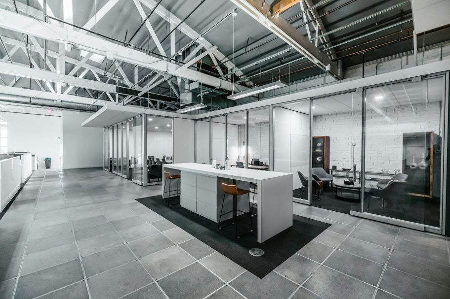 Verteilung + Alarmanlage Bürokomplex Moderne Büroumgebung mit gläsernem Besprechungsraum und heller, offener Fläche.